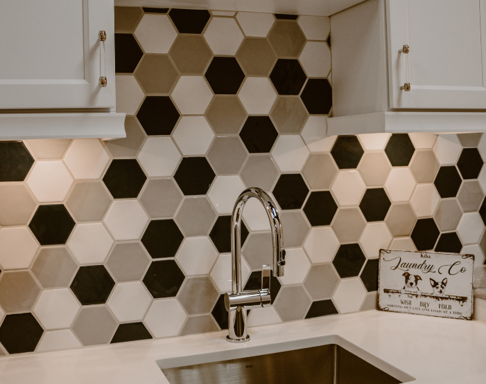 Mosaic hexagonal tile backsplash in a kitchen behind a stove